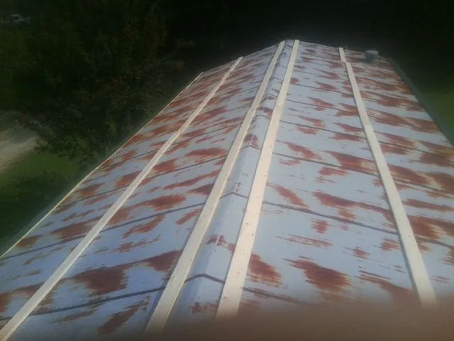 Rusted metal roof panels with new wood purlins before replacement — Storm Damage Roof Repair in Pembroke Township by Roofing Brothers