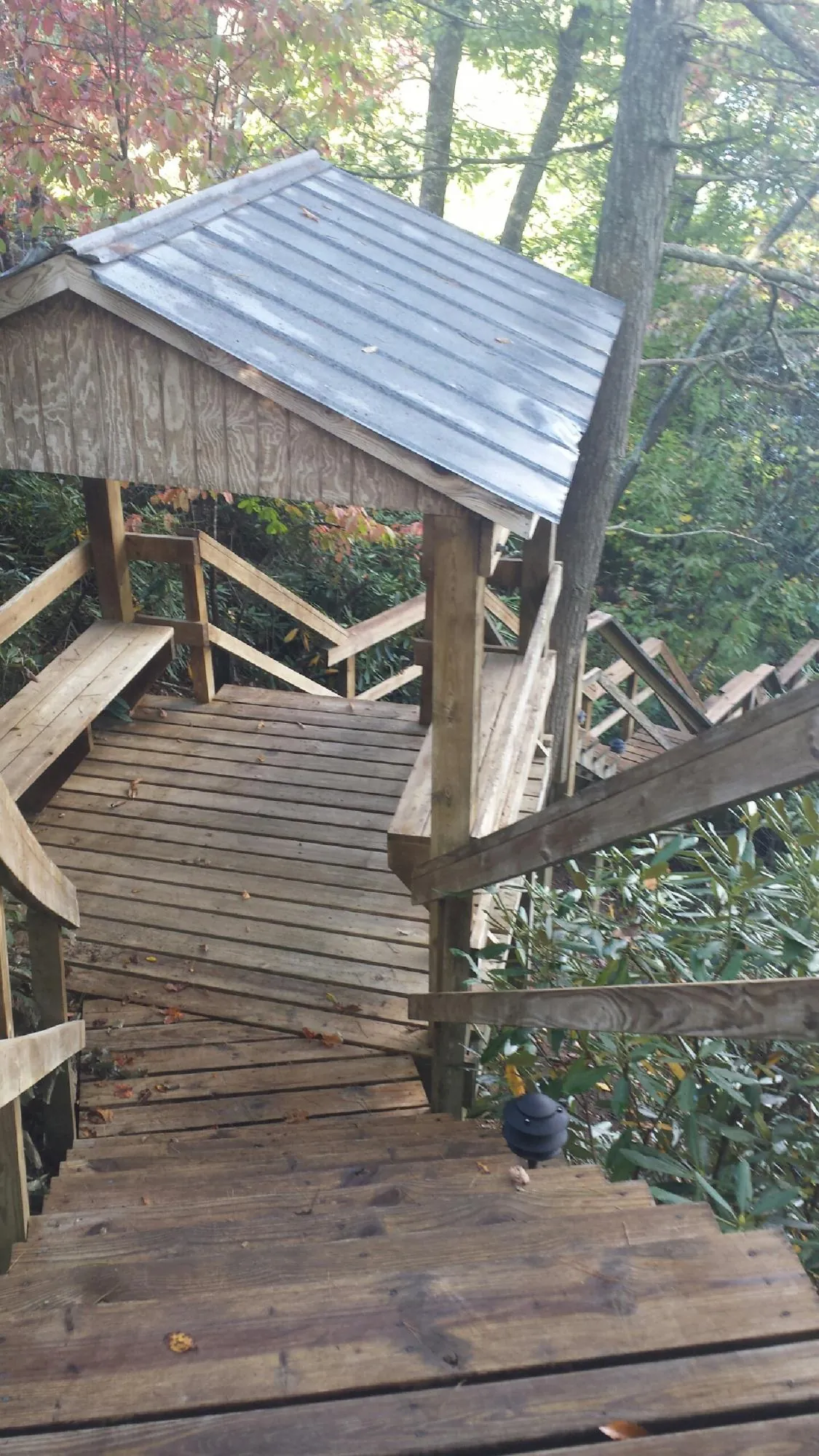 Metal roofed shelter over wooden steps on a wooded walkway — Skylight Repair & Installation work by our crew in Pembroke Township
