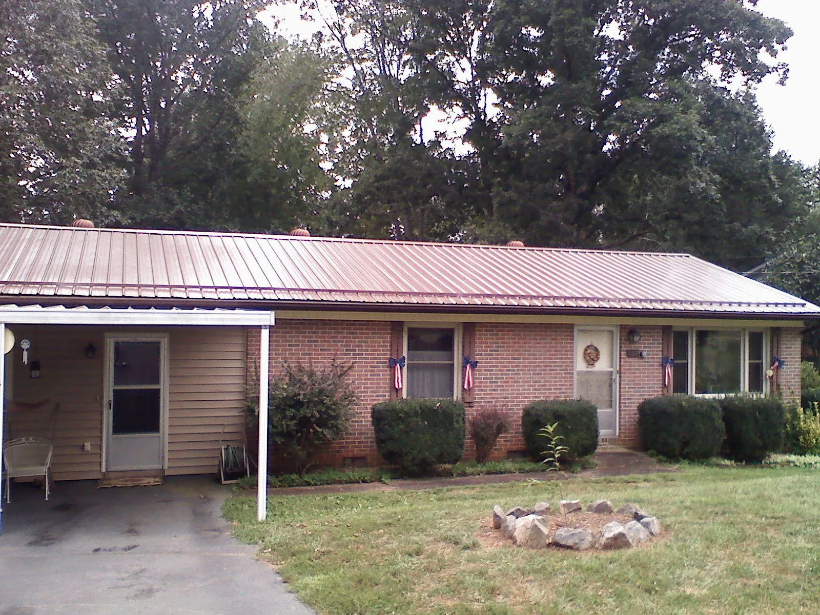 Bronze metal roof and carport on a brick ranch home — Roof Repair work by our crew in Pembroke Township