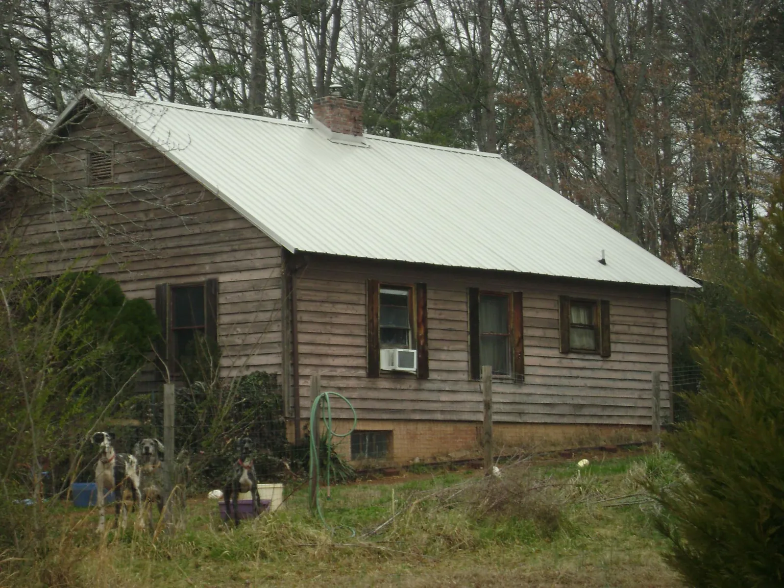 White metal roof on an old wood sided farmhouse, from a Asphalt Shingle Roof Repair job in Pembroke Township